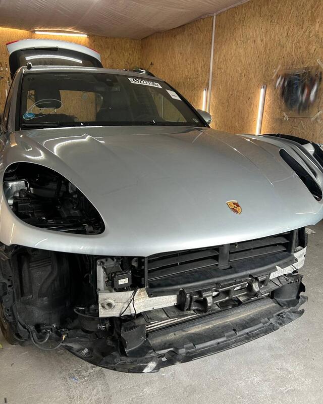 Porsche Macan bez zderzaka w&nbsp;naszej lakierni, ściany z&nbsp;płyt OSB.
